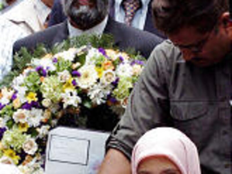 A mixed-faith group from Leeds, Britain, lays flowers during a memorial service near Kings Cross Station in London, site of a July 7 bombing.