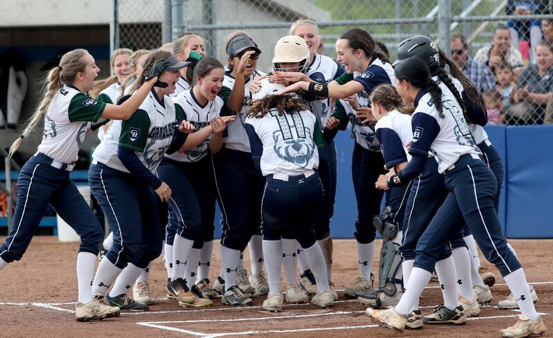Makaiya Gomez is greeted at home plate by her Copper Hills teammates after blasting a two-run homer during the 6A semifinal softball game against Herriman at the SLCC softball field in Taylorsville on Monday, May 27, 2019.