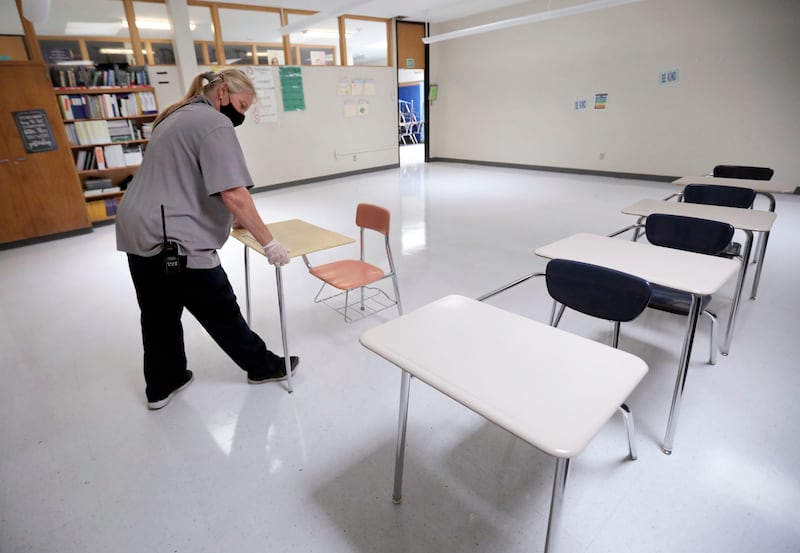 Skyline High School custodian Stephanie Harrill sets up desks in a freshly cleaned classroom athe school in Millcreek in July 2020.