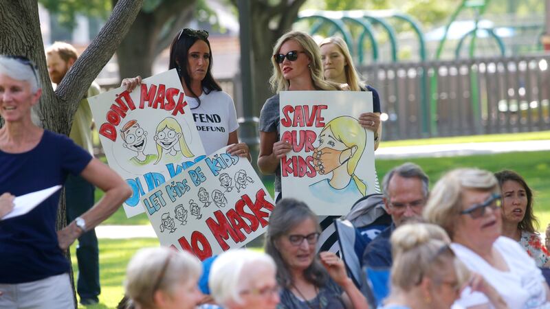 Stephanie Grant, left, and Tiffany Barker joins others during an anti-mask rally Wednesday, Aug. 5, 2020, in Orem, Utah.