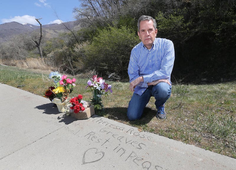 Scott Fisher poses next to a marker left by neighbors and friends in memory of Theresa Rose Greaves, whose body was found on the hillside behind the marker 31 years after she went missing in 1983, Friday, April 3, 2015, in Fruit Heights. Fisher is the hos