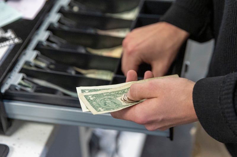 Almighty Originals manager Jamison Parker counts a customer’s change at the Shops at South Town in Sandy.