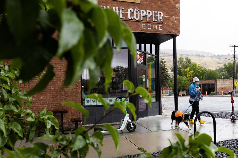 Britt and her dog Harvey walk out of Blue Copper Coffee on a rainy Labor Day in Salt Lake City on Monday.