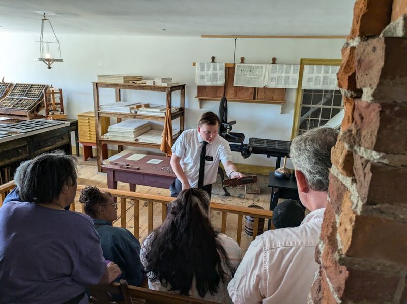 A young full-time missionary stands in front of a group using American Sign Language in the Grandin Building in Palmyra, New York.