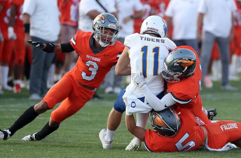 Skyridge’s Smith Snowden (3), Collin Sheffield (5) and Saxon Higbee (14) tackle Orem’s Isaac Yokota (11).