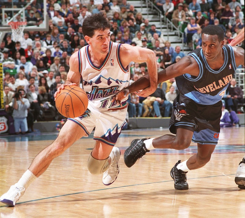 John Stockton, wearing white, drives around Cleveland’s Brevin Knight.
