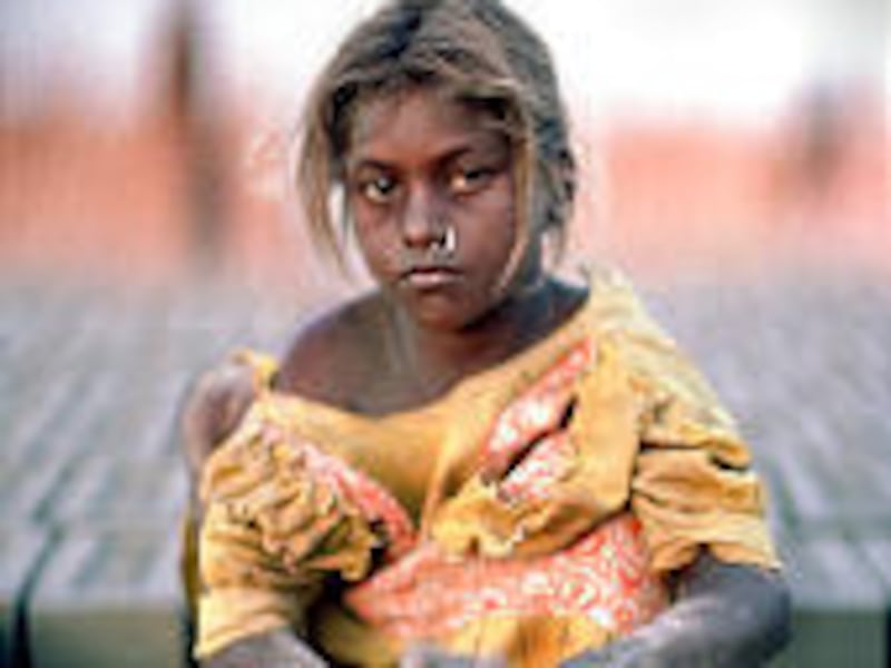 A young slave girl pulls clay from a brick form in "Stolen Childhoods."