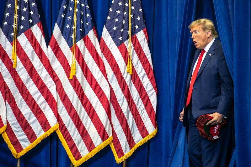 Former President Donald Trump is introduced to the crowd as he walks to the stage at a caucus event in Cedar Rapids, Iowa.