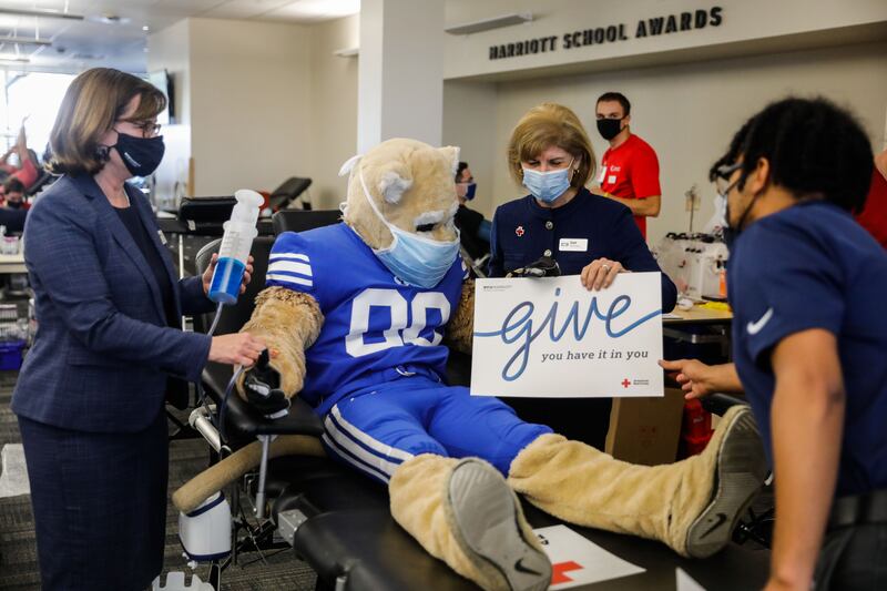 American Red Cross president and CEO Gail McGovern prepare for a photo with BYU mascot Cosmo the Cougar at a blood drive.