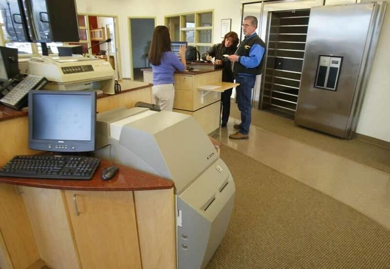 A teller helps customers at Credit Union One March 5, 2004. A higher percentage of Credit Unions offer free checking accounts than banks.