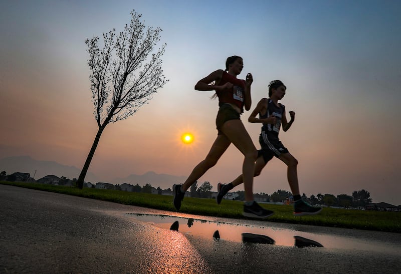 Livi Nelson, left, runs with her brother Noah during the Labor Day Pun Run 5K race.
