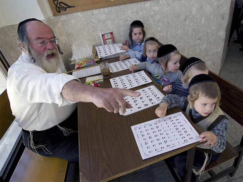 Ultra-Orthodox Jewish children sit in front of a teacher as they learn the alphabet at the Shomrei HaHoma Torah School for boys in Jerusalem's Mea Shearim neighbourhood in Israel on Nov. 9, 2010.
