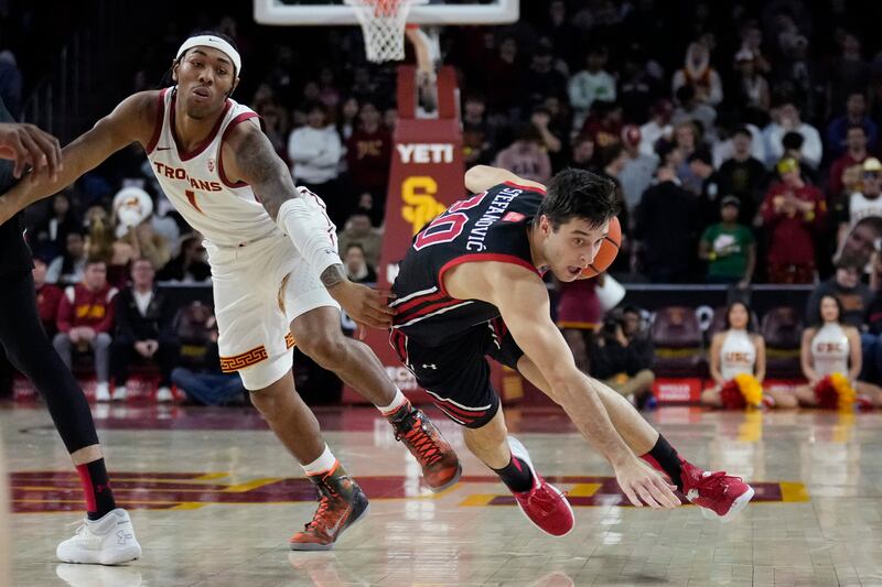 Utah guard Lazar Stefanovic, right, dribbles past Southern California guard Malik Thomas (1) during the first half of an NCAA college basketball game Saturday, Jan. 14, 2023, in Los Angeles. (AP Photo/Marcio Jose Sanchez)