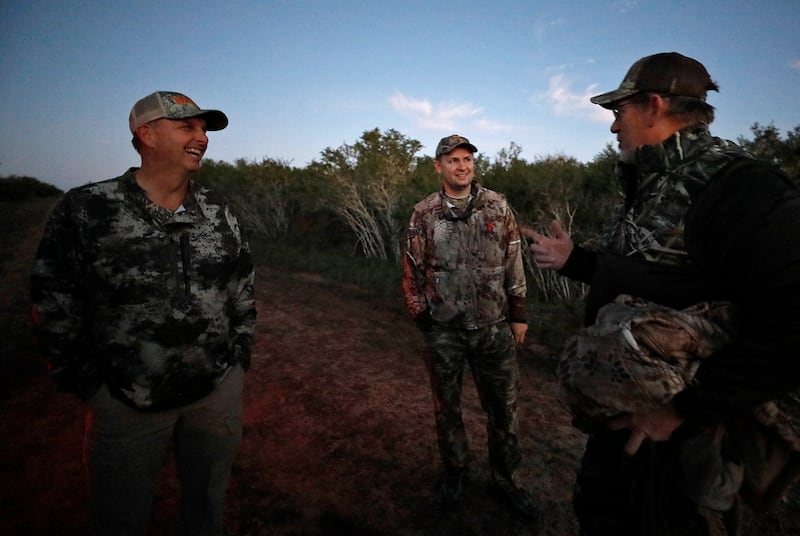 Ty Detmer (from left) jokes with hunters Anthony Johnson and his father AJ Johnson, from Saratoga Springs, Utah, on Detmer's T14 Ranch Thursday, Nov. 15, 2018, near Freer, Texas.