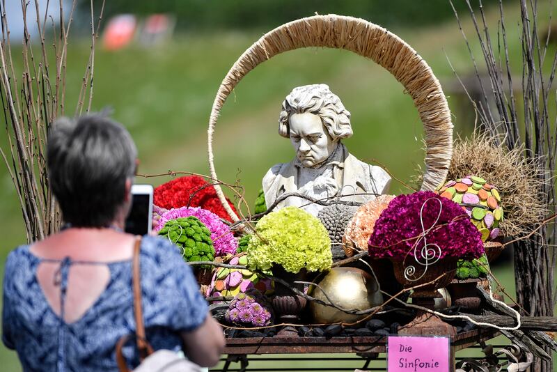 A sculpture of the German classical composer Beethoven is displayed between flowers during the North Rhine-Westphalia state horticultural show at a former coal mine compound in Kamp-Lintfort, Germany, Friday, June 12, 2020.