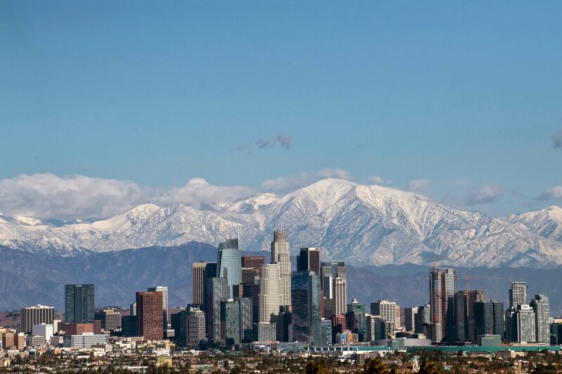 Snow covers the mountains behind downtown Los Angeles, Tuesday, Dec. 29, 2020.