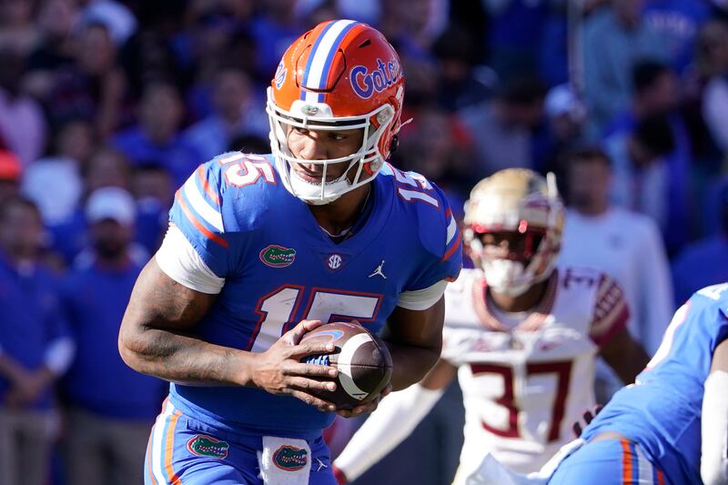 Florida quarterback Anthony Richardson hands off the ball as his is rushed by Florida State defensive back Omarion Cooper.