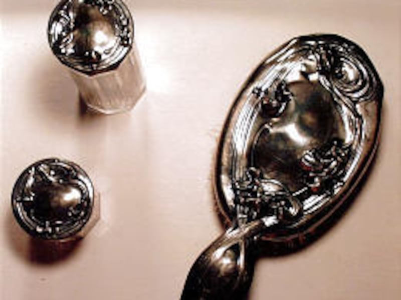 The Art Nouveau motifs on this silver and glass dresser set are of great interest to collectors.