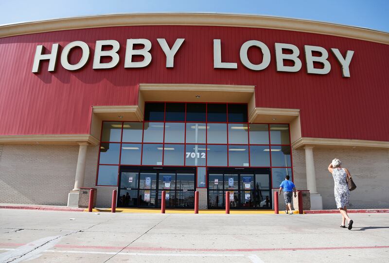 FILE - In this June 30, 2014, file photo, customers walk to a Hobby Lobby store in Oklahoma City. Federal prosecutors say Hobby Lobby Stores has agreed to pay a $3 million federal fine and forfeit thousands of ancient Iraqi artifacts smuggled from the Mid
