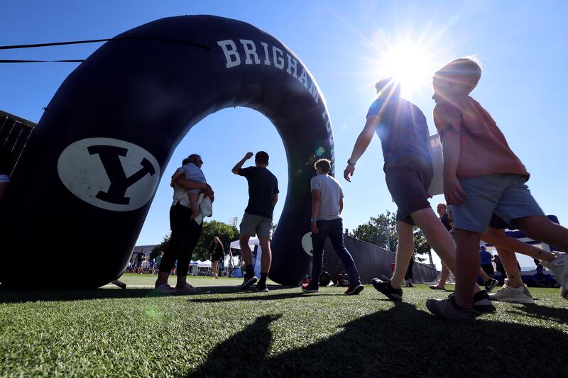 People walk under a BYU banner