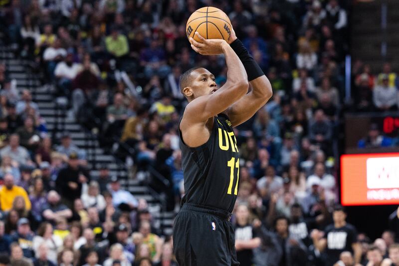 Utah Jazz guard Kris Dunn (wearing black) shoots the ball