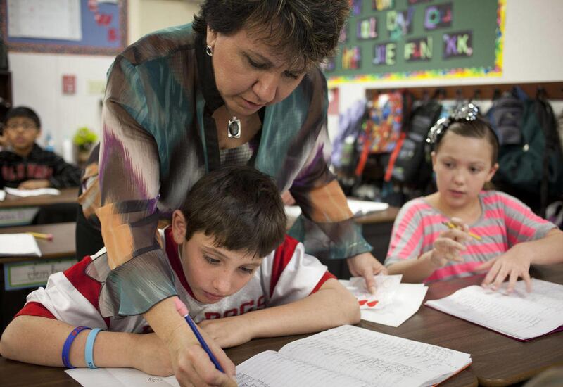 Patti Karr checks Justin Kramer's spelling words in her 4th grade classroom at Franklin Northeast Elementary School in Mesa, Ariz., on Feb. 6, 2012. For more than a quarter-century, Mesa's Franklin schools have been teaching kids to read and write in a