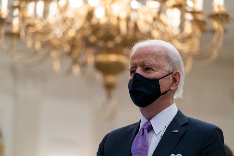 President Joe Biden stands during a performance of the national anthem, during a virtual Presidential Inaugural Prayer Service in the State Dinning Room of the White House, Thursday, Jan. 21, 2021, in Washington.