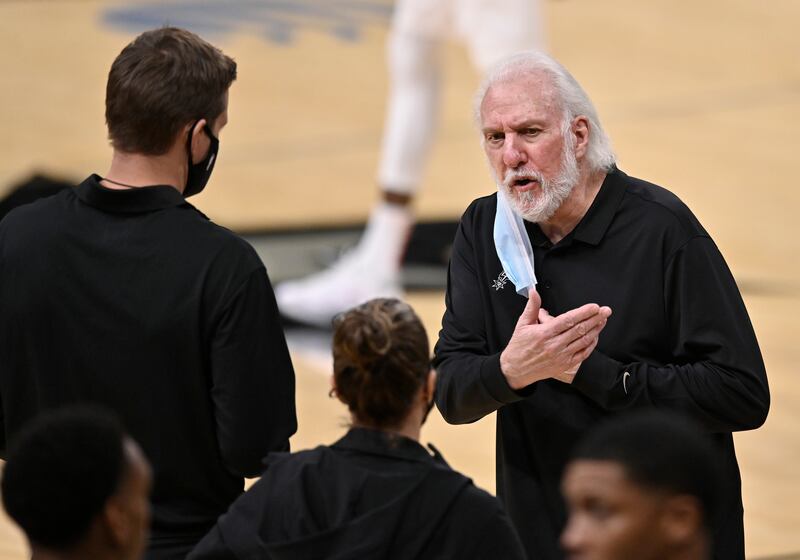 San Antonio Spurs coach Gregg Popovich talks to assistant coaches Becky Hammon and Will Hardy.