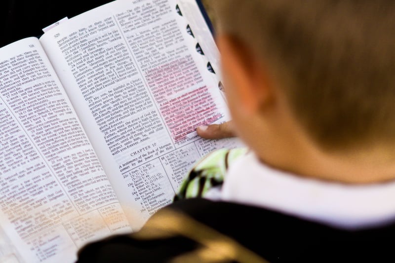 A boy reads the Book of Mormon.