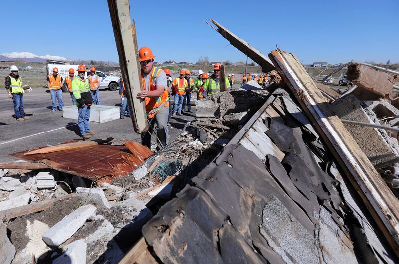A participant clears debris during Salt Lake County's combined emergency training exercise during the Great Utah ShakeOut at the Welby Pit in South Jordan on Thursday, April 18, 2019. The exercise was held with the Utah Department of Transportation, Salt