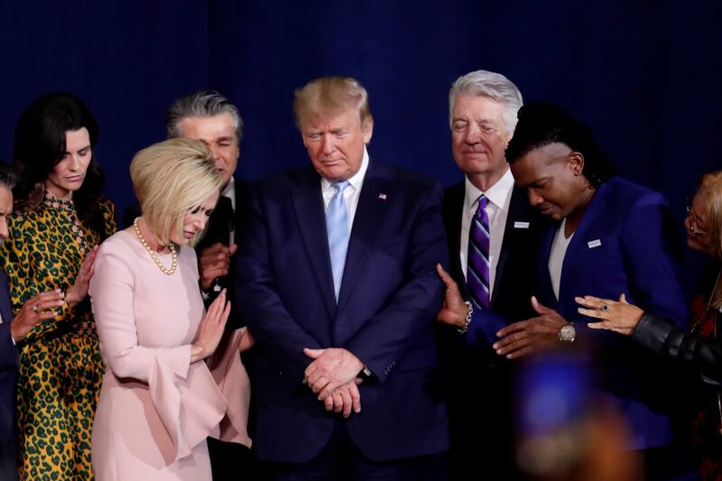 Pastor Paula White, left, and other faith leaders pray with President Donald Trump, center, during a rally for evangelical supporters at the King Jesus International Ministry church in 2020 in Miami.
