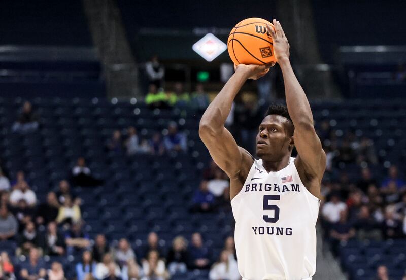 Brigham Young Cougars forward Gideon George , wearing white, shoots a 3-pointer as the Brigham Young Cougars play the Northern Iowa Panthers in an NIT game.