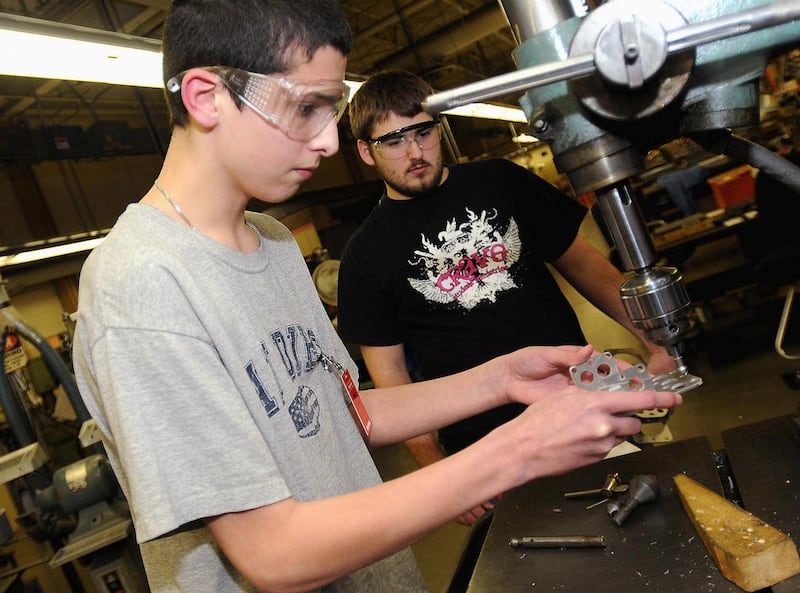 ADVANCE FOR USE SUNDAY, APRIL 8 AND THEREAFTER - In this 2011 photo, Freeport High School freshman Hayden Wolfe, left, drills holes into a piece for his team's robot as senior Matt Gorham watches at Honeywell in Freeport, Ill. They are part of the Metalhe