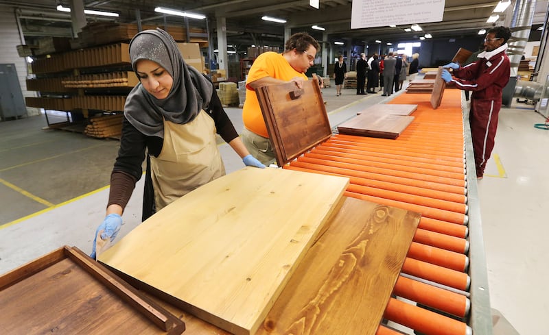 A refugee builds furniture that will be donated to help other refugees resettle in the United States.