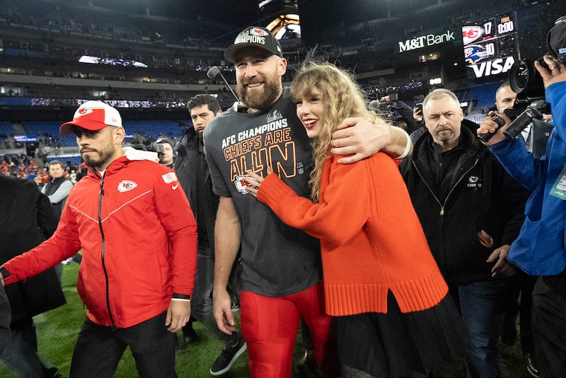 Travis Kelce and Taylor Swift walk together after a football game in Baltimore.