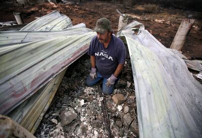 Doug Adams takes a break while looking through the rubble of his Fruitland house for an old broken boat propeller that has sentimental value on Wednesday, July 11, 2018. The house was destroyed in Dollar Ridge Fire.