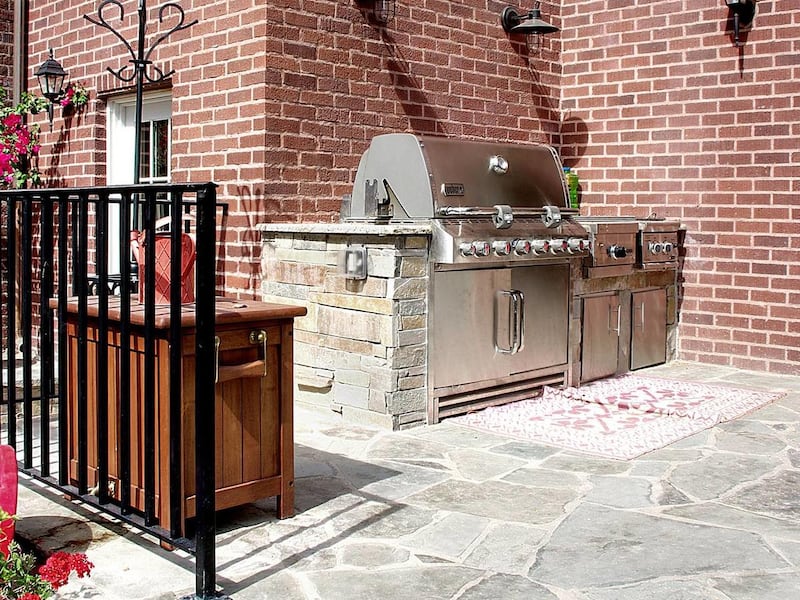 Adding a barbecue built into a countertop and a food preparation area turns a simple patio into an outdoor kitchen.