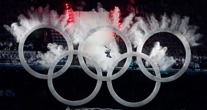 A snowboarder sails through the Olympic rings during the opening ceremony for the Vancouver 2010 Olympics.