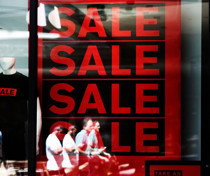 Shoppers walk by a sale sign at Express Men in City Creek Center in Salt Lake City.