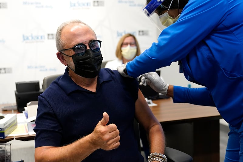 Music producer Emilio Estefan, 67, gives the thumbs-up while he receives the Pfizer-BioNTech COVID-19 vaccine at Jackson Memorial Hospital, Wednesday, Dec. 30, 2020, in Miami.