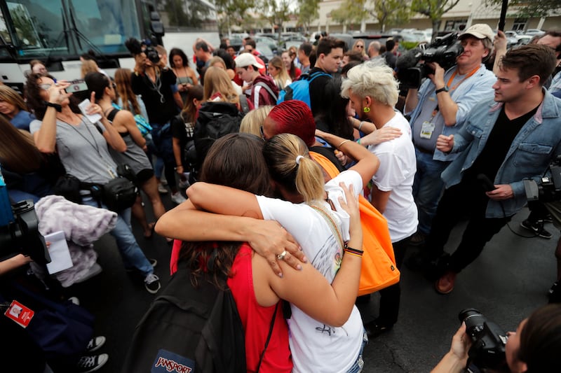 Students from Stoneman Douglas High School, hug survivors of the Pulse nightclub shooting before boarding buses in Parkland, Fla., Tuesday, Feb. 20, 2018.