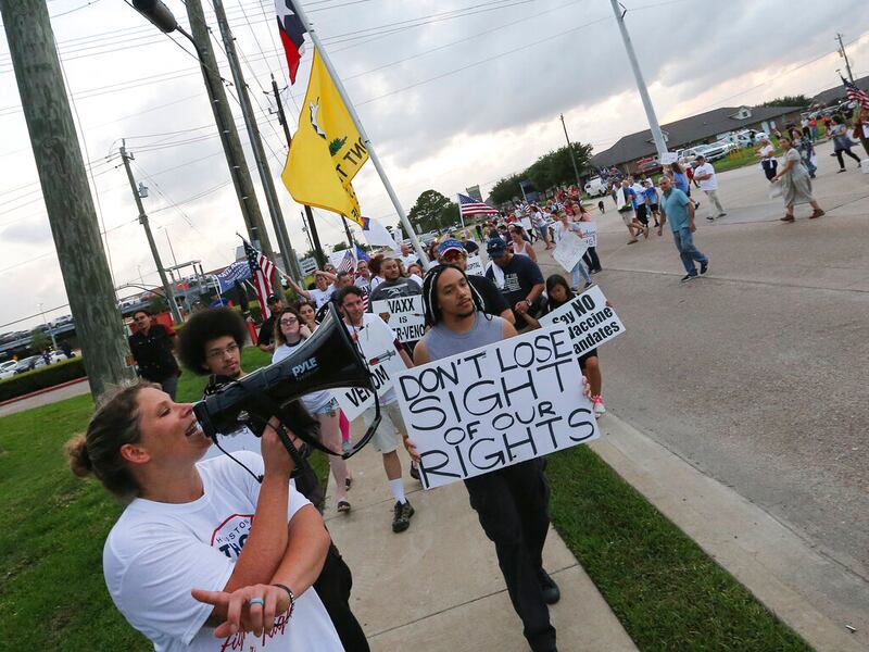 Jennifer Bridges leads people marching past protest Houston Methodist Baytown Hospital in Baytown, Texas.