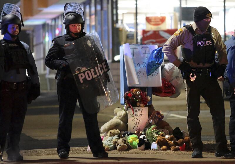 FILE - In a Wednesday, Dec. 24, 2014 file photo, police guard the entrance to a gas station in front of a memorial to Antonio Martin, in Berkeley, Mo. Officials said Tuesday, Dec. 30, 2014 that an internal police investigation confirmed that Martin pointe
