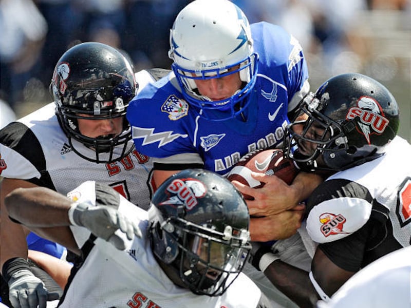 Air Force quarterback Shea Smith, center, fights his way through<BR> a crowd of SUU defenders and scores a first-quarter touchdown.