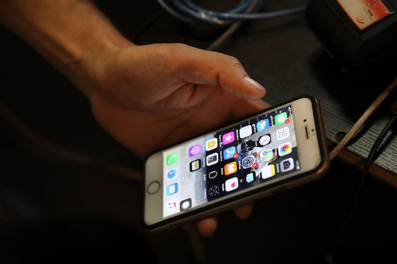 A man works on his cell phone at an internet cafe in Tehran, Iran.