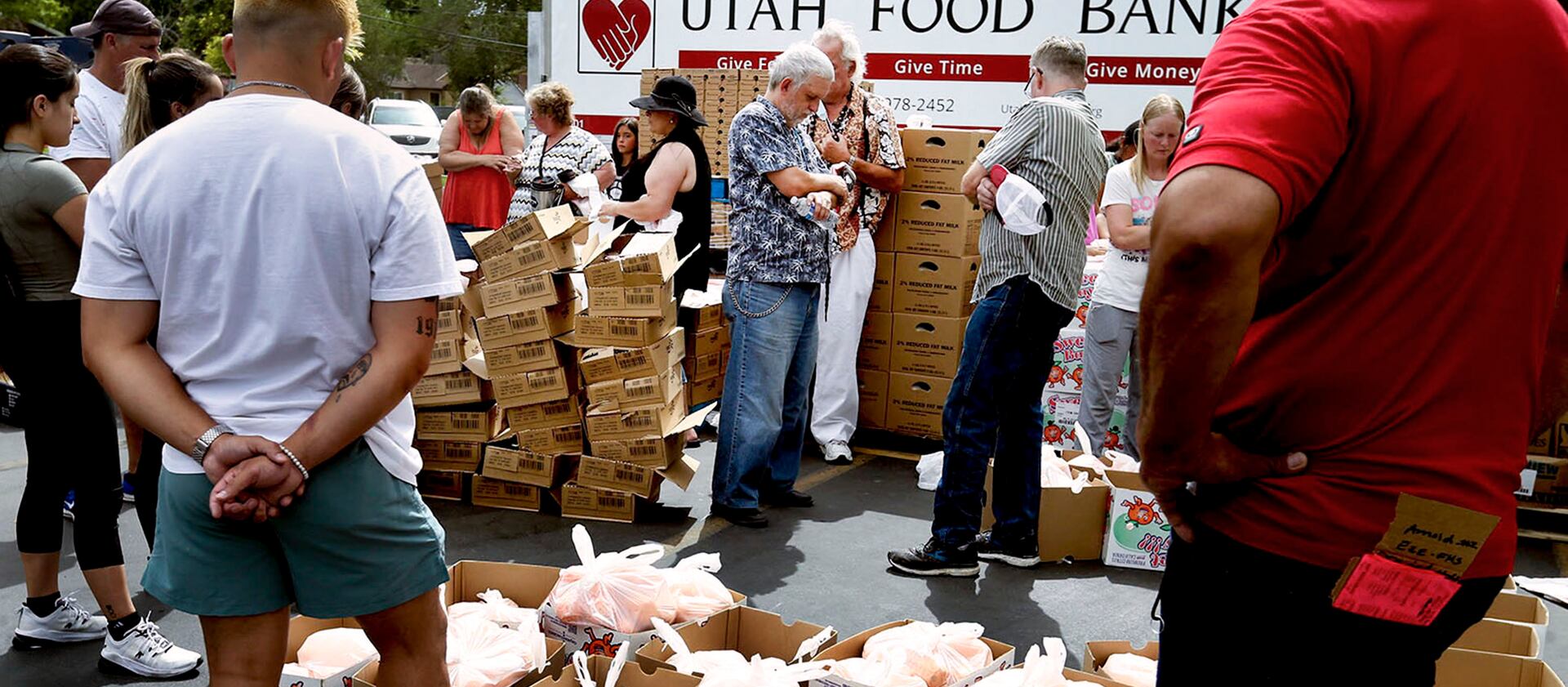 Volunteers pray before handing out food at the Utah Food Bank mobile pantry at The Church of Jesus Christ of Latter-day Saints Cannon Stake Center. Food banks have played a key role, along with government aid, in holding food insecurity pretty stable in the pandemic.