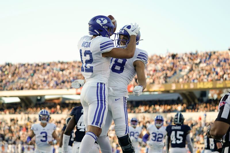 BYU wide receiver Puka Nacua (12) celebrates with wide receiver Gunner Romney (18) after scoring a touchdown.