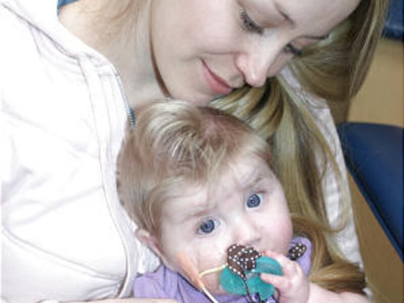 Mimi McDonald holds her 10-month-old daughter, Mia. Both have critical aortic stenosis and have undergone several heart surgeries. Mia recently had a heart transplant.