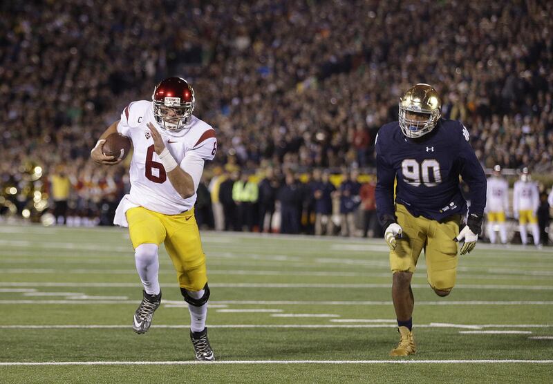 Southern California's Cody Kessler (6) runs three yards for a touchdown against Notre Dame's Isaac Rochell (90) during the first half of an NCAA college football game Saturday, Oct. 17, 2015, in South Bend, Ind. (AP Photo/Darron Cummings)