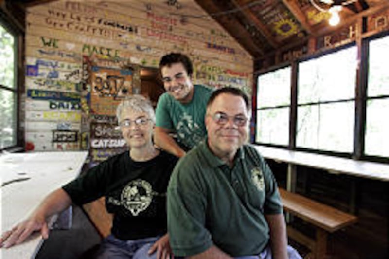 Lisa Eby, her husband, Jim, right, and their son, Web, sit inside the crafts cabin at Camp Tu-Endie-Wei in Elgin, Ill.